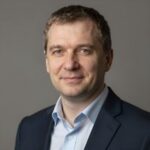Профессиональный портрет уверенного российского бизнесмена на нейтральном размытом фоне в студийном освещении